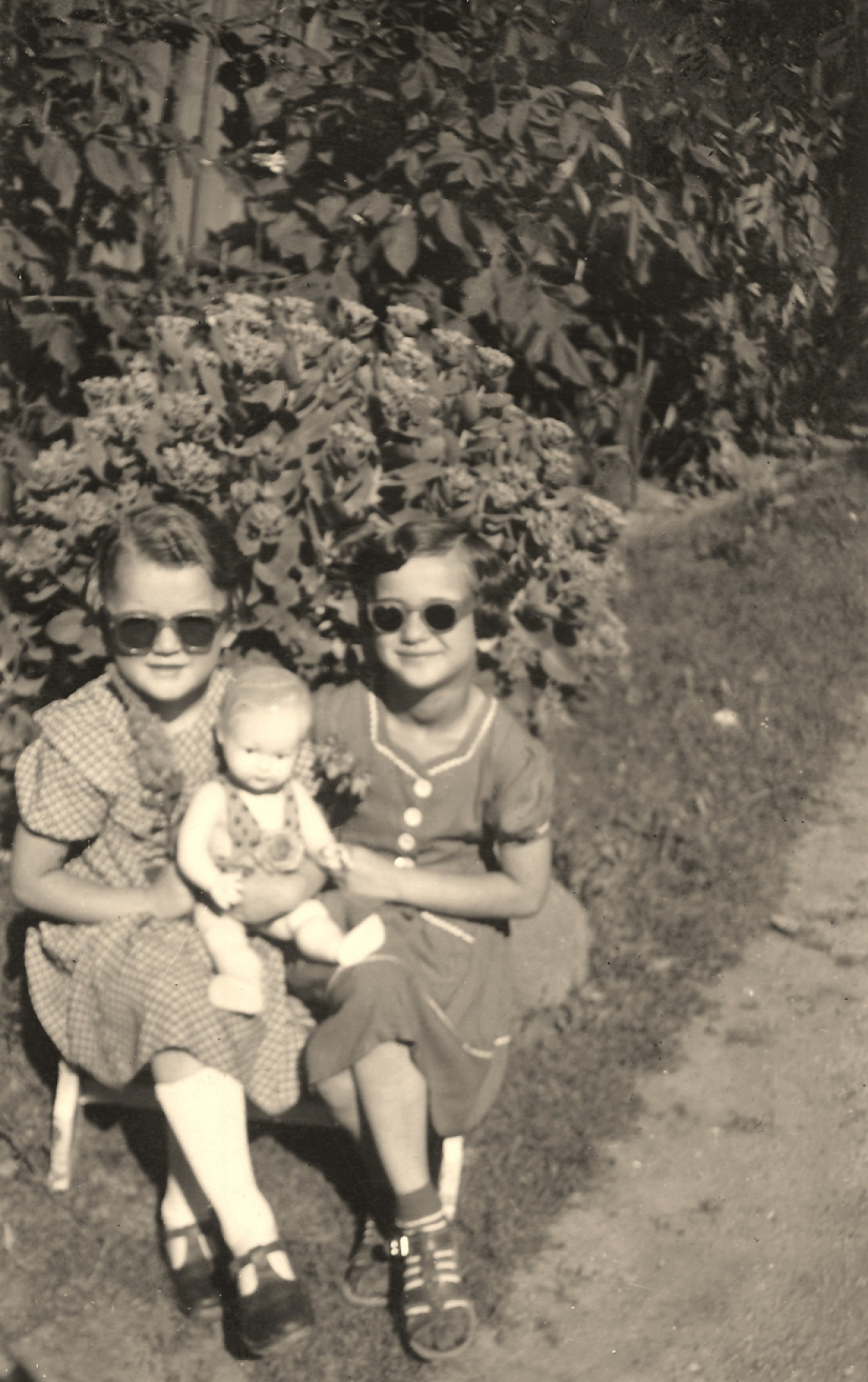 Zwei Freundinnen: Helene Böcskör und Elisabeth Szendi mit Sonnenbrillen und Puppe