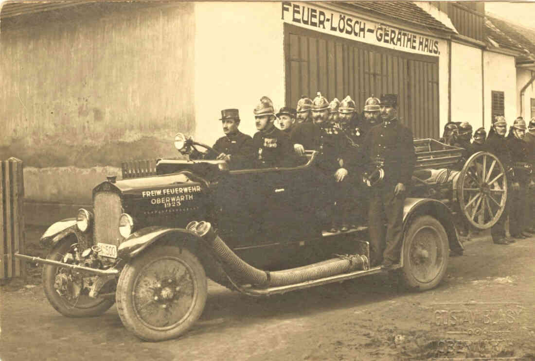Freiwillige Feuerwehr: Löschfahrzeug mit Mannschaft vor dem Feuerwehrhaus (Bahnhofstraße 5) - Seper/Hutter