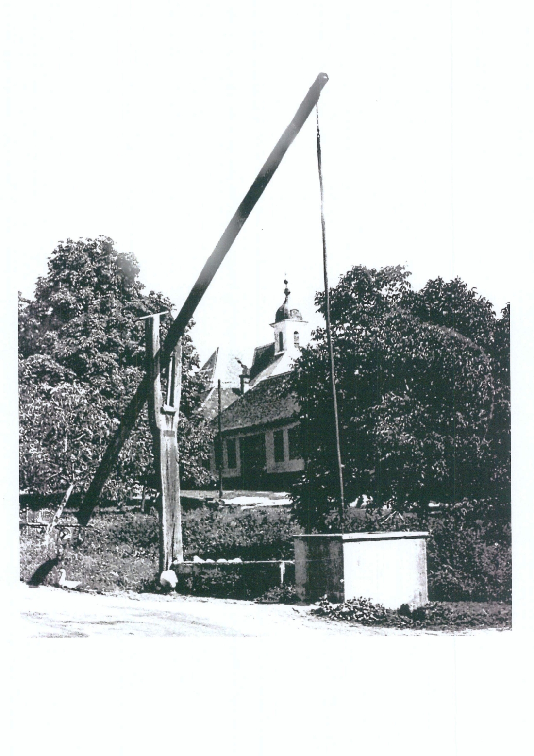 Ziehbrunnen am Dorfanger in St. Martin - im Hintergrund die dem Hl. Martin geweihte röm. kath. Pfarrkirche
