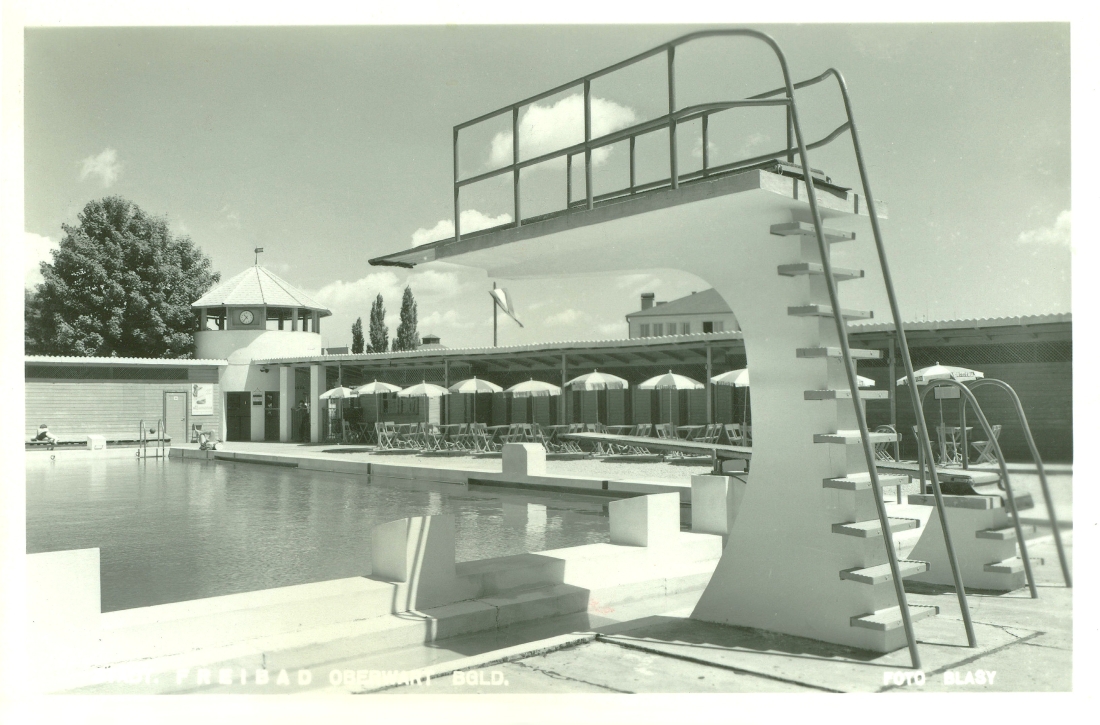 Städtisches Schwimmbad: Freibad (Badgasse 6) - Blick über den Sprungturm auf die Schirme und Tischgarnituren des Badbuffets