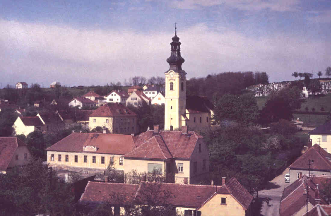 Blick auf die röm. kath. Pfarrkirche Maria Himmelfahrt - in der Bildmitte links die Schule , darüber das Pfarrhaus; im Hintergrund der röm. kath Friedhof