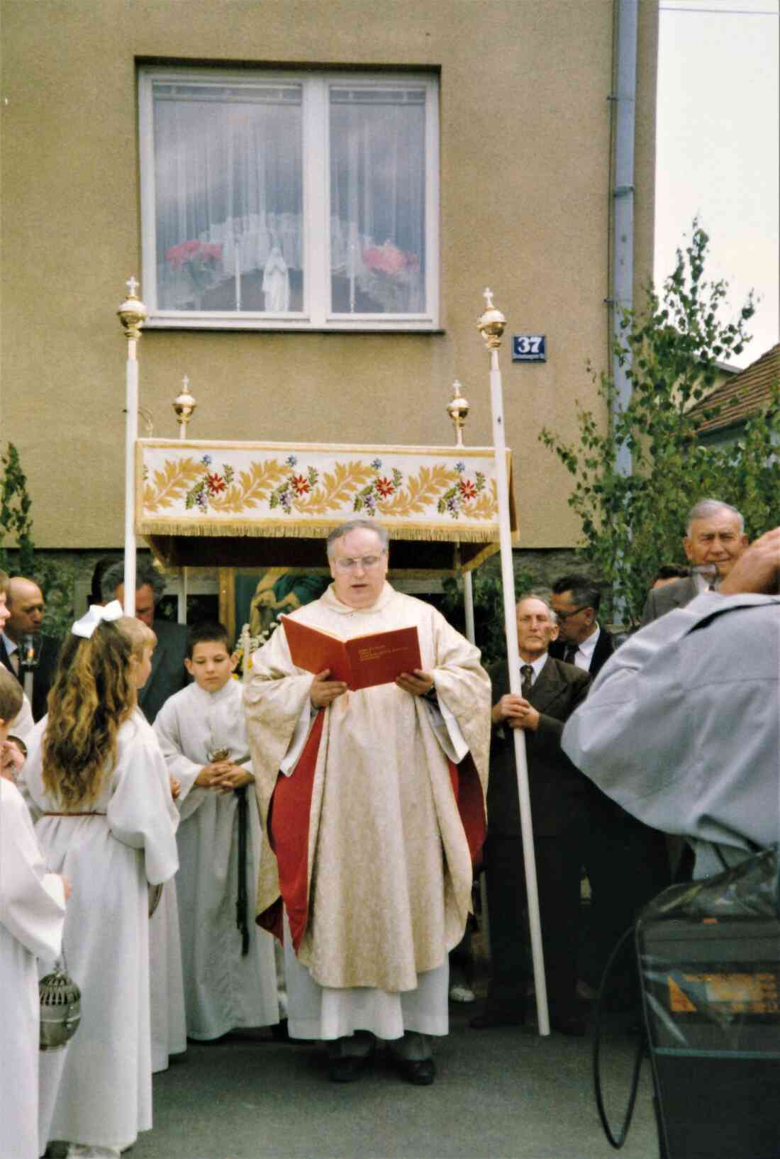 Röm. kath. Pfarre: Fronleichnamsprozession - Pfarrer Schwarz vor dem Altar beim Haus Lonyai (Steinamangererstraße 17)
