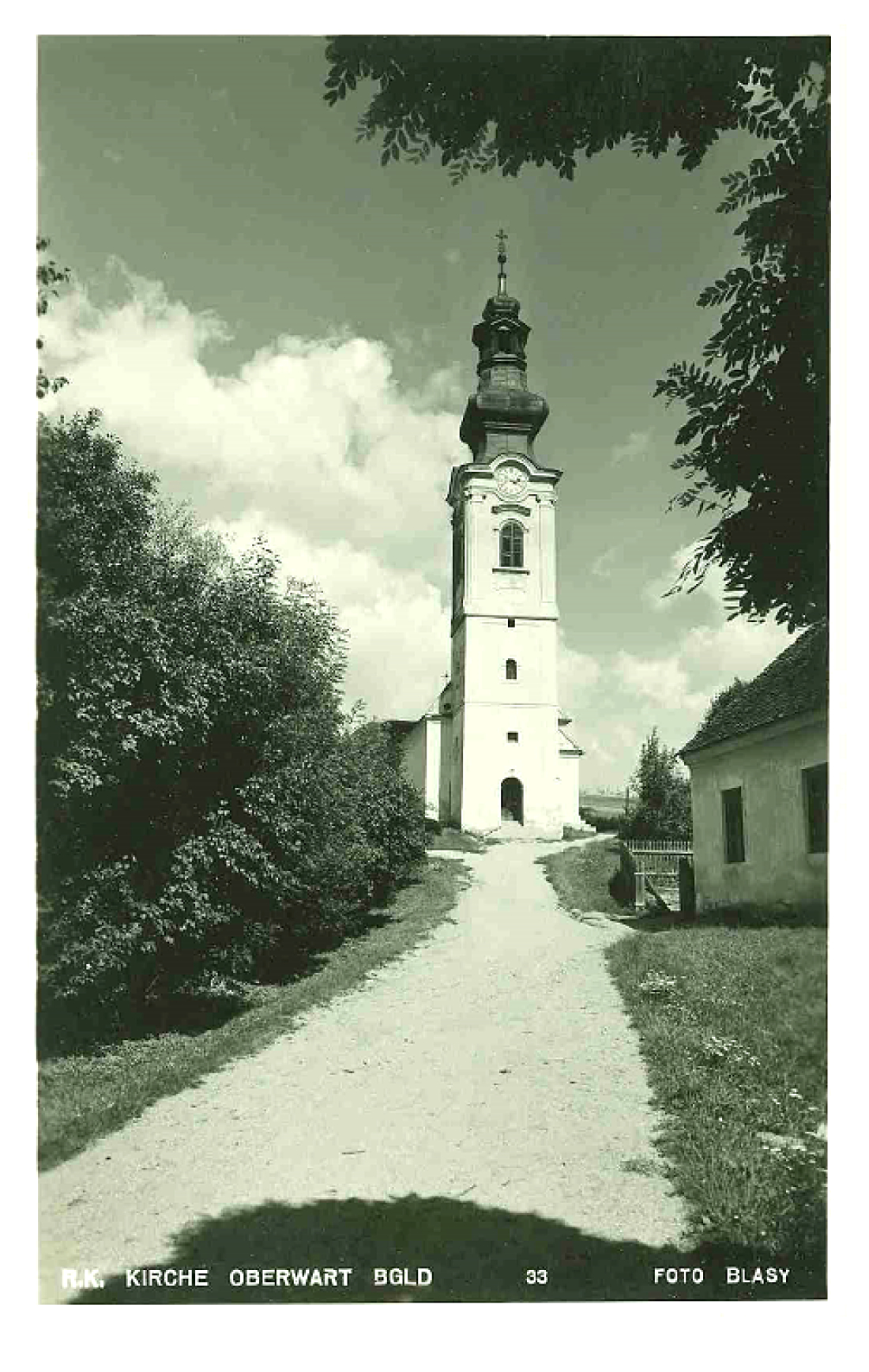 Die römisch-katholische Pfarrkirche Maria Himmelfahrt und ein Mauereck der kath. Volksschule