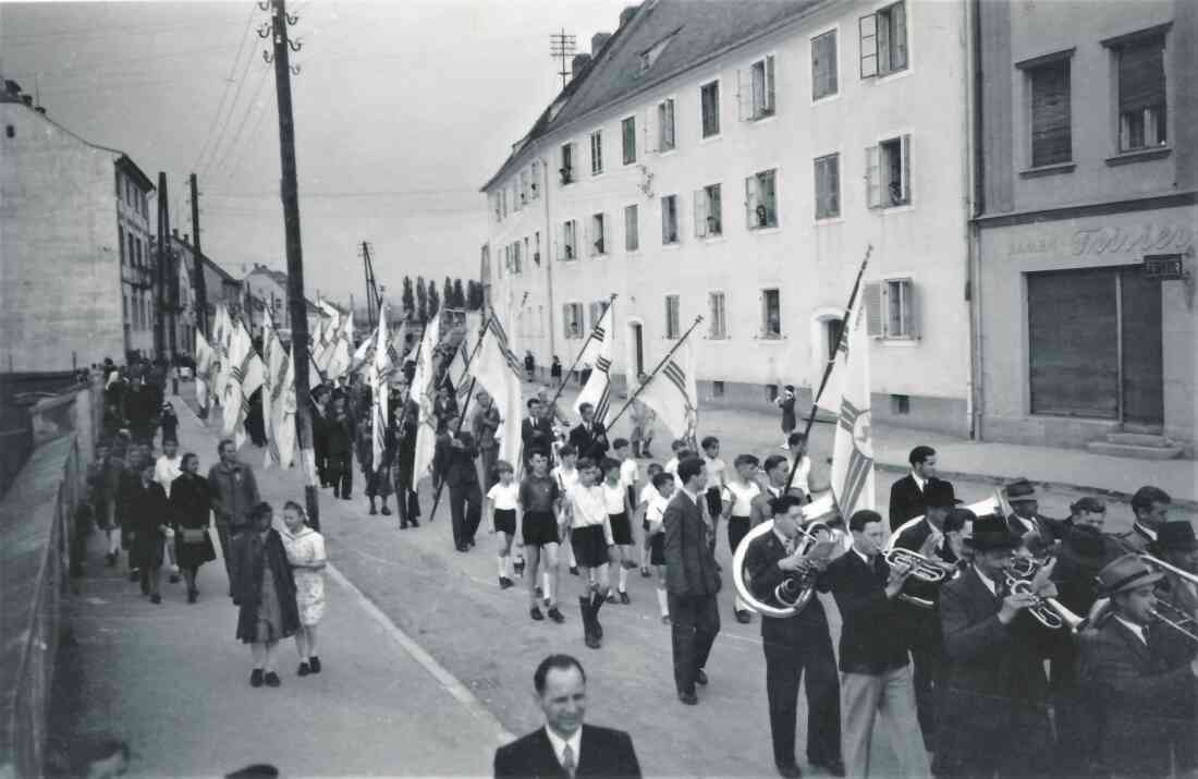 Festzug mit Blasmusik und Fahnen der Kath. Jugend (vor Wienerstaße 19)