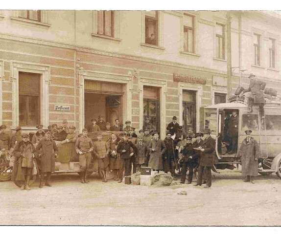 Personengruppe mit Bundesheer, Postbeamten und einem Autobus posieren vor dem Gebäude OW 145b / Hauptplatz 10