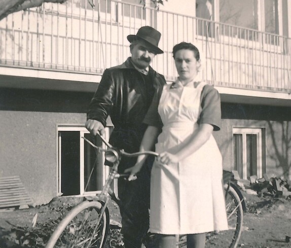 Frieda Folkensteiner (Köchin) und Herr Toni (Hausarbeiter) mit seinem Dienstfahrrad vor der Südfront des Krankenhauses (Spitalgasse / heute Dr.-Emmerich-Gyenge-Platz)