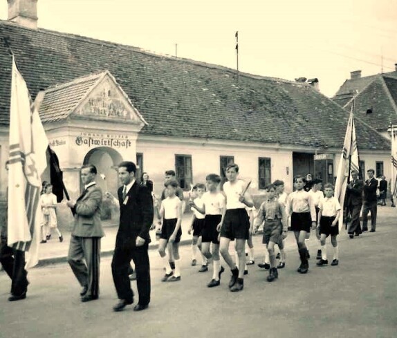 Festzug mit Fahnen der Kath. Jugend vor der Gastwirtschaft Johann Ruiter (Wienerstaße 1)