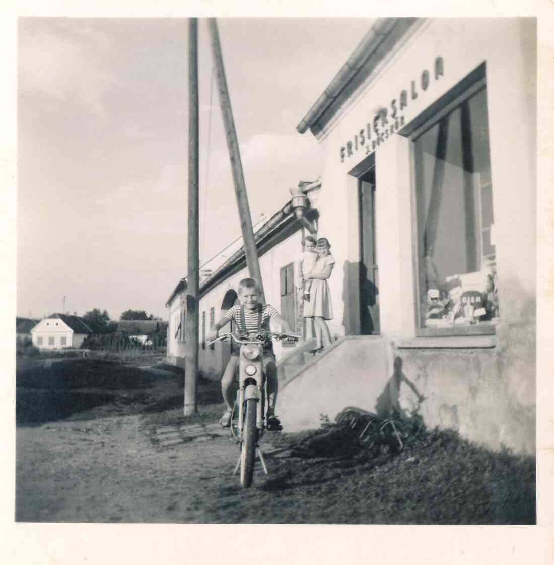 Sohn Ladislaus auf einem Moped vor dem Frisiersalon seines Vaters Johann Böcskör (Grazerstraße 31)