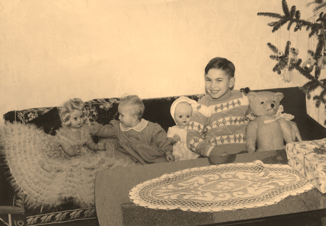Brigitte Imre und Alexander Adorjan mit Puppen und dem Teddy am Sofa