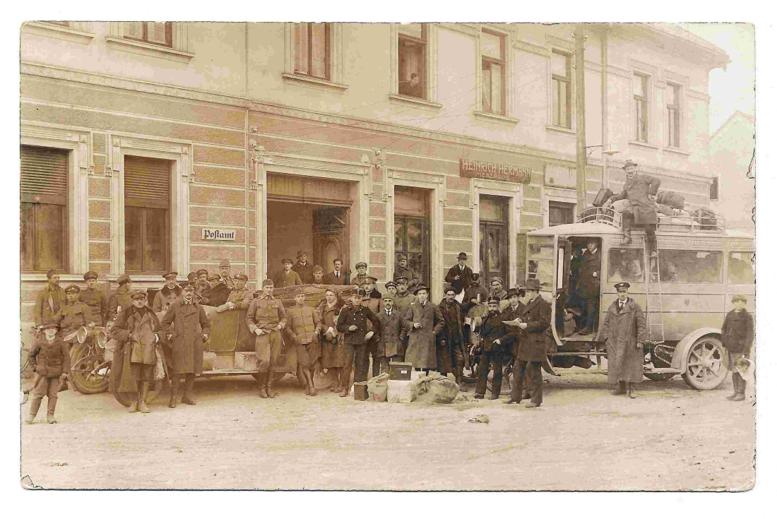 Personengruppe mit Bundesheer, Postbeamten und einem Autobus posieren vor dem Gebäude OW 145b / Hauptplatz 10