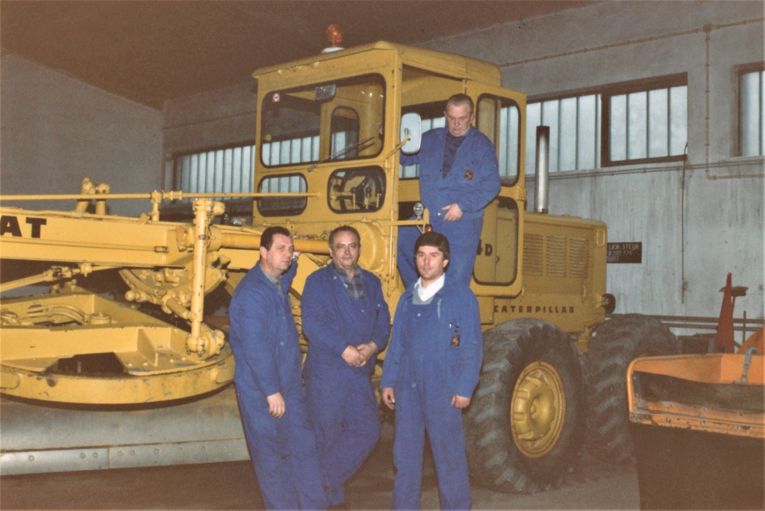 Bauamt: Mitarbeiter vor einem Gräder der Marke Caterpillar in der Werkshalle (Wienerstraße 53) - Straßenbaubezirksamt: Pathy/Frebel/Pollak/Hegedüs