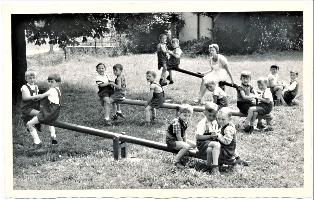 Die Buben einer Gruppe des städtischen Kindergarten auf den neuen Schaukeln mit Pädagogin Martha Jelinek
