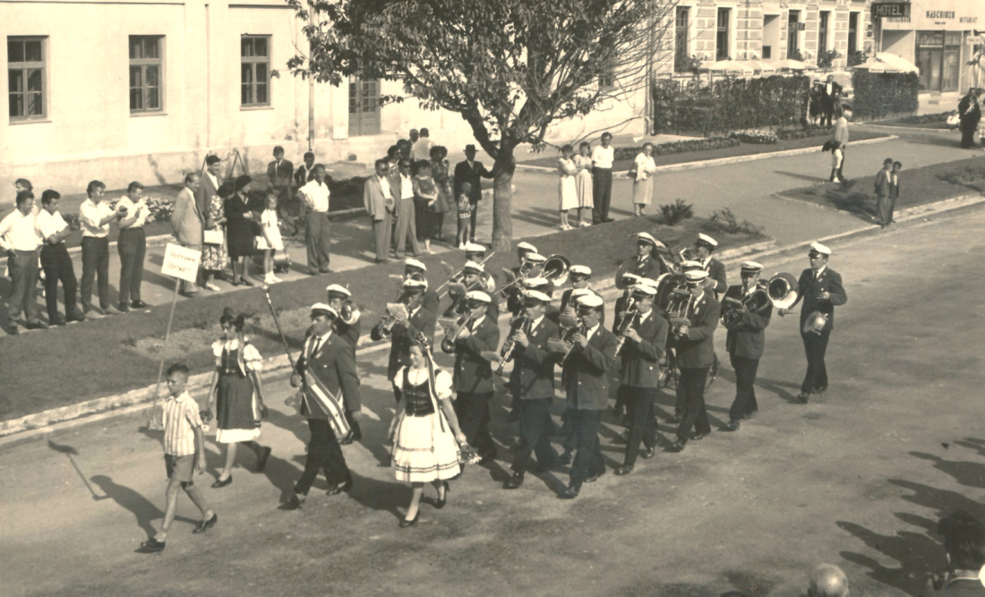 Stadtkapelle: Blasmusiktreffen - Marschformation vor dem Gebäude der Bezirkshauptmannschaft (wahrscheinlich) anlässlich des 10-jährigen Bestansjubiläums