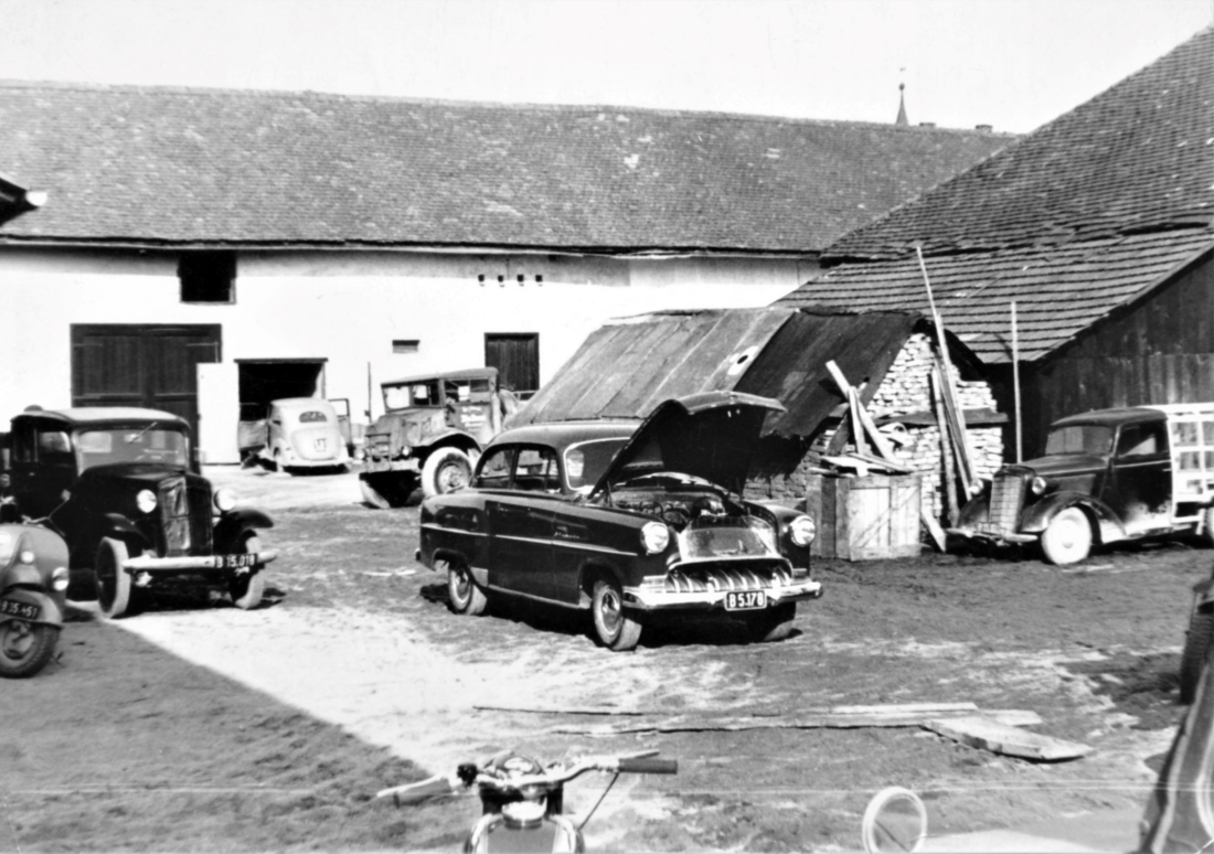Reparaturwerkstätte Palank: Blick in den Hof gegen Norden mit diversen Autos, LKW-s und Zweirädern